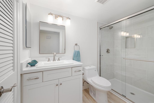 bathroom with vanity, hardwood / wood-style flooring, toilet, and walk in shower