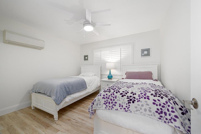 bedroom featuring a wall mounted air conditioner, ceiling fan, and light hardwood / wood-style floors