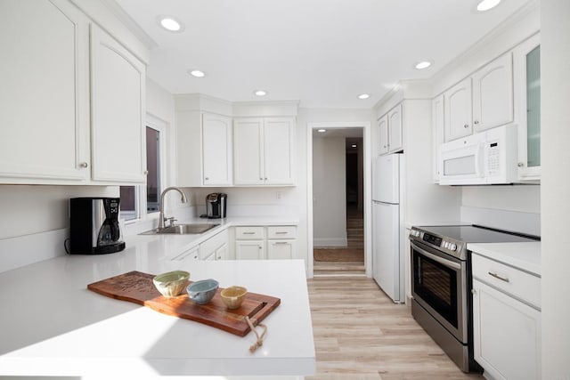 kitchen with white cabinetry, sink, white appliances, and light wood-type flooring