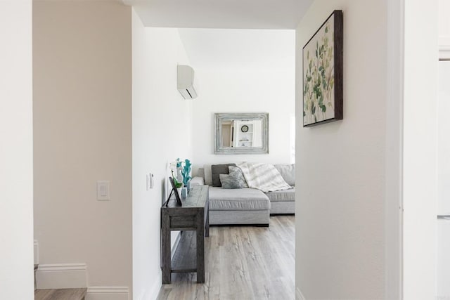 hallway featuring light hardwood / wood-style floors and a wall unit AC