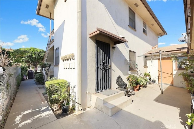 view of exterior entry with a patio area