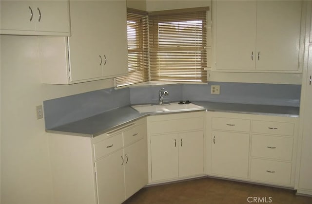 kitchen featuring white cabinetry and sink