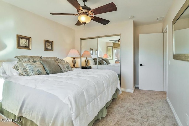 carpeted bedroom with ceiling fan and a closet