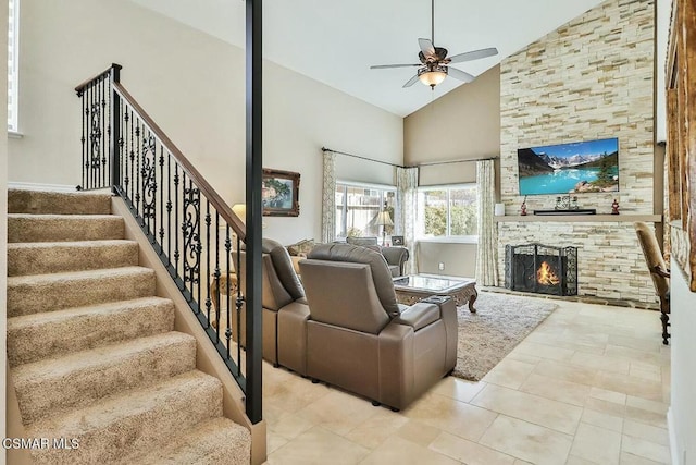 living room featuring a large fireplace, high vaulted ceiling, and ceiling fan