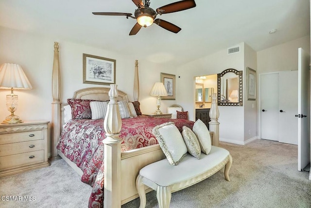 bedroom with ensuite bath, ceiling fan, and light carpet