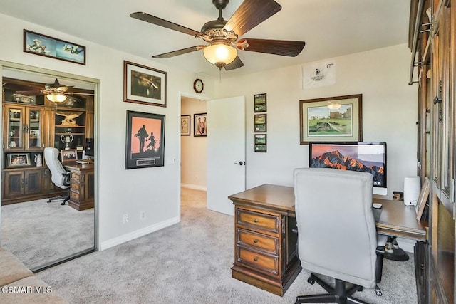 carpeted office space featuring ceiling fan