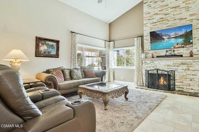 living room featuring a fireplace, light tile patterned floors, high vaulted ceiling, and ceiling fan