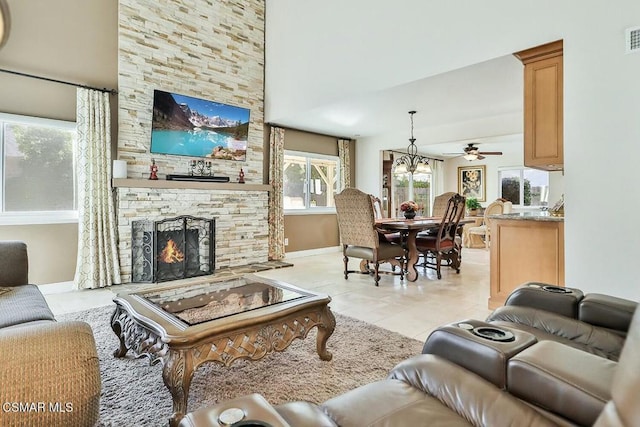 living room featuring a fireplace, ceiling fan, and light tile patterned flooring