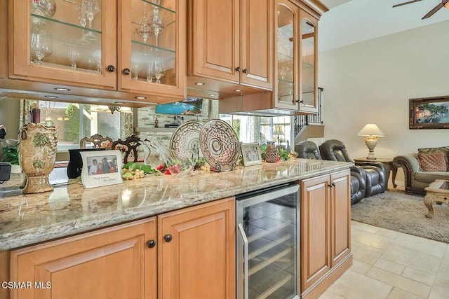 bar featuring light tile patterned flooring, wine cooler, plenty of natural light, and light stone counters