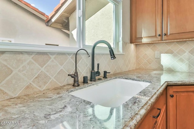 details featuring tasteful backsplash, sink, and a skylight