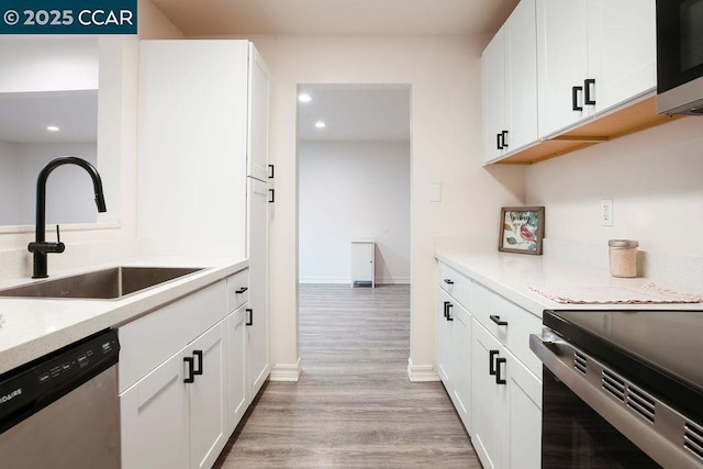 kitchen with light hardwood / wood-style flooring, stainless steel appliances, white cabinetry, and sink