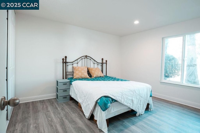 bedroom with hardwood / wood-style floors and multiple windows