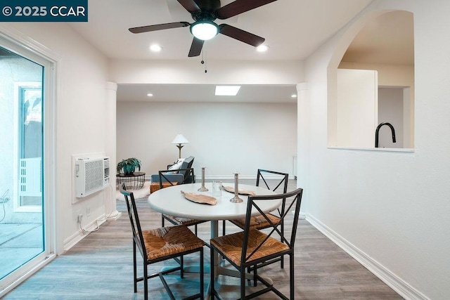 dining area featuring a wall mounted AC, dark hardwood / wood-style flooring, and ceiling fan