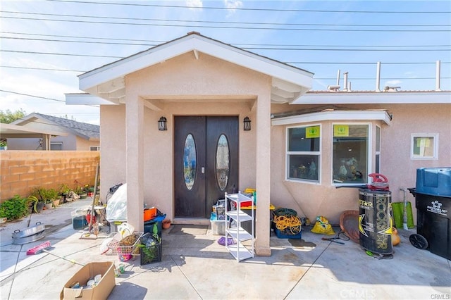 view of exterior entry with a patio area