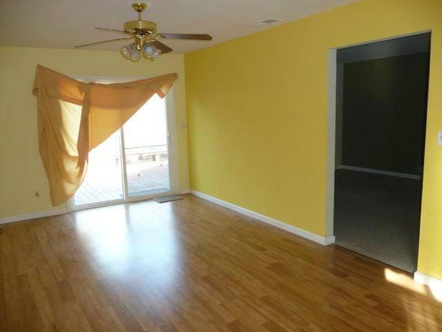 empty room with ceiling fan and wood-type flooring