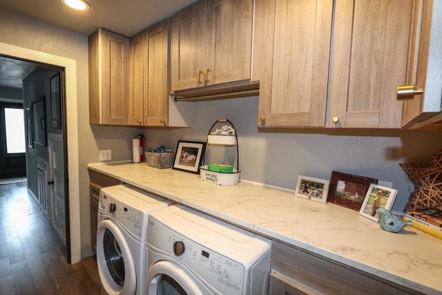 clothes washing area with cabinets, dark wood-type flooring, and independent washer and dryer