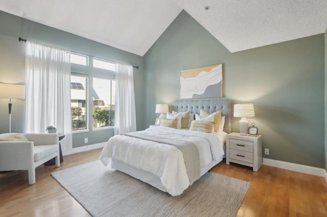 bedroom with light wood-type flooring and lofted ceiling