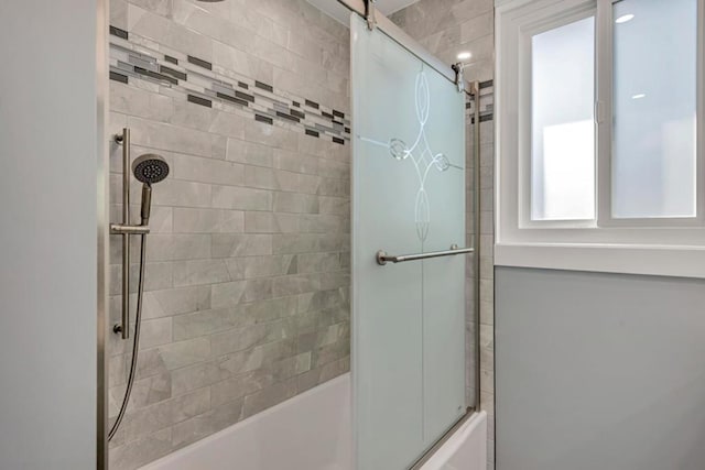 bathroom with shower / bath combination with glass door