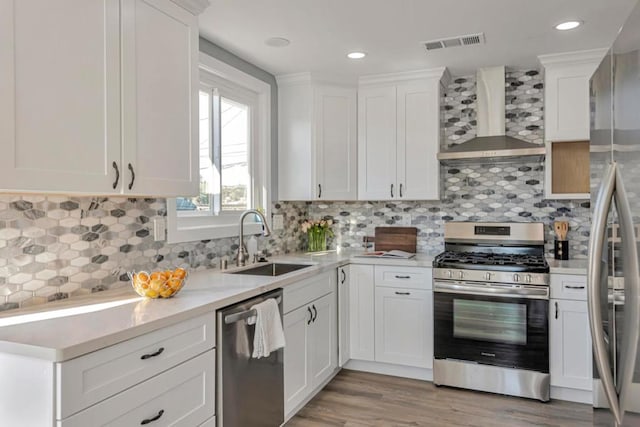 kitchen with sink, wall chimney range hood, stainless steel appliances, and tasteful backsplash