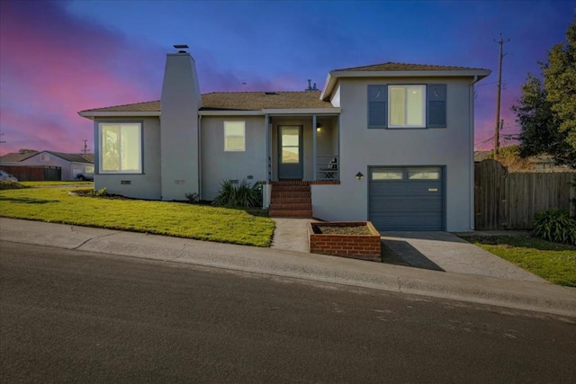 view of front of home featuring a garage and a lawn