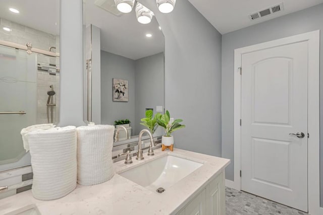 bathroom with a shower with door and vanity