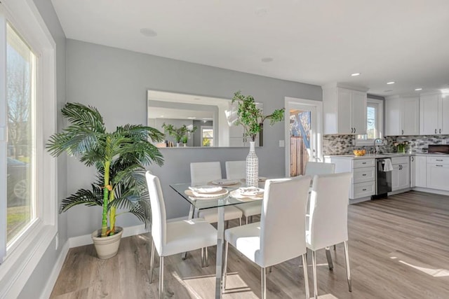 dining space with light hardwood / wood-style flooring and sink