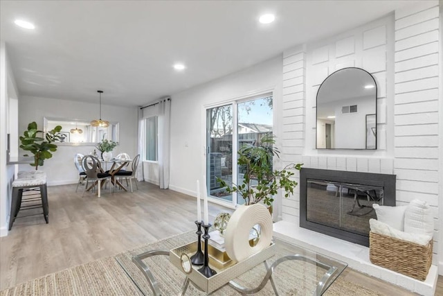 living room with a brick fireplace and hardwood / wood-style floors