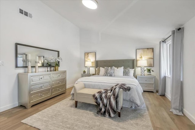 bedroom featuring lofted ceiling and light hardwood / wood-style floors