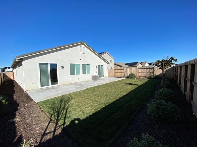 rear view of property featuring central AC, a yard, and a patio area