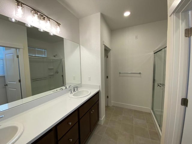 bathroom with tile patterned floors, vanity, and a shower with door