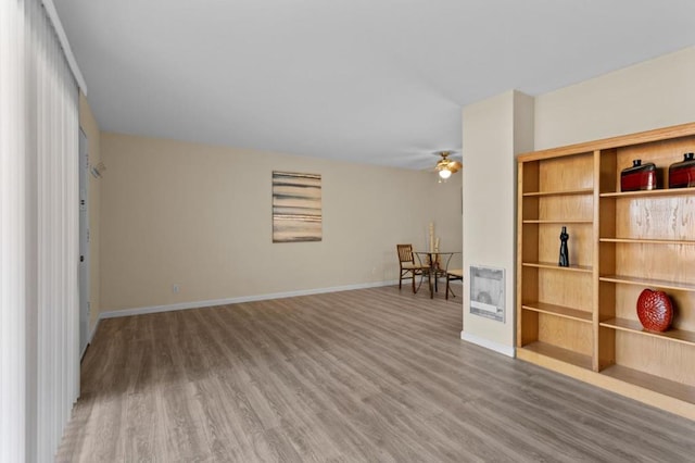 interior space featuring hardwood / wood-style flooring, heating unit, and ceiling fan