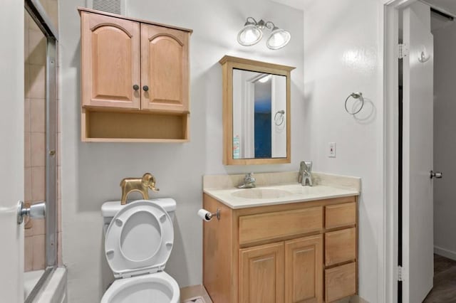 full bathroom with toilet, enclosed tub / shower combo, and vanity