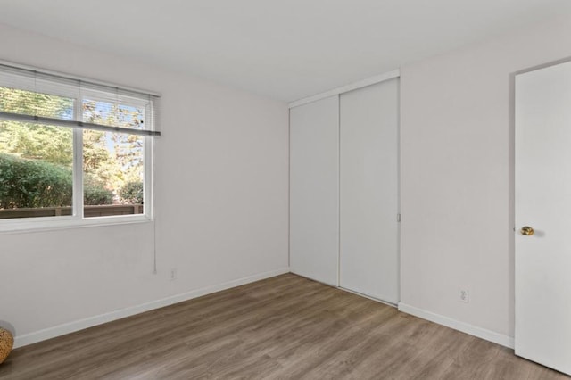 unfurnished bedroom with a closet and hardwood / wood-style flooring