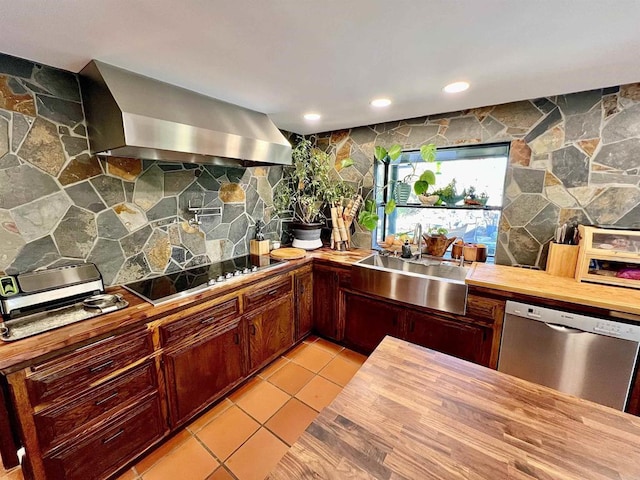 kitchen with wooden counters, black electric stovetop, wall chimney exhaust hood, sink, and stainless steel dishwasher