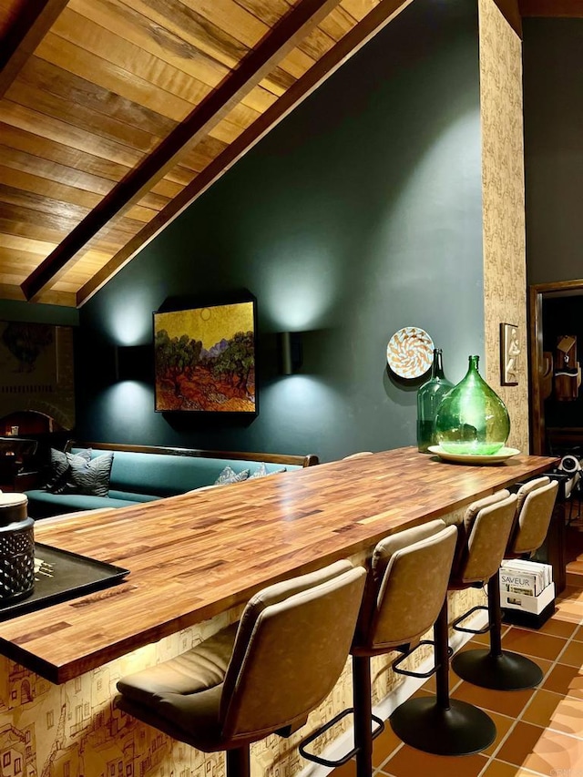 bar with butcher block countertops, wooden ceiling, vaulted ceiling, and tile patterned flooring