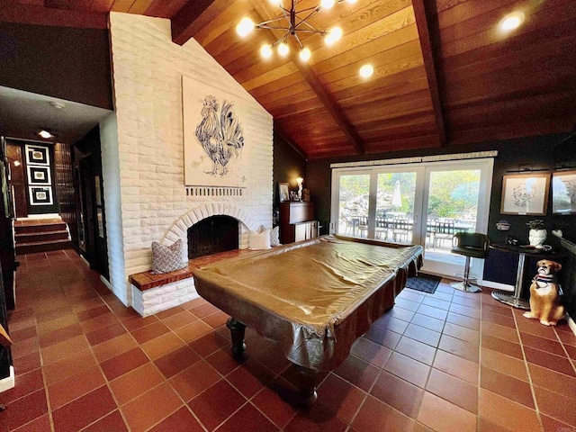 playroom featuring pool table, a brick fireplace, dark tile patterned floors, and beamed ceiling