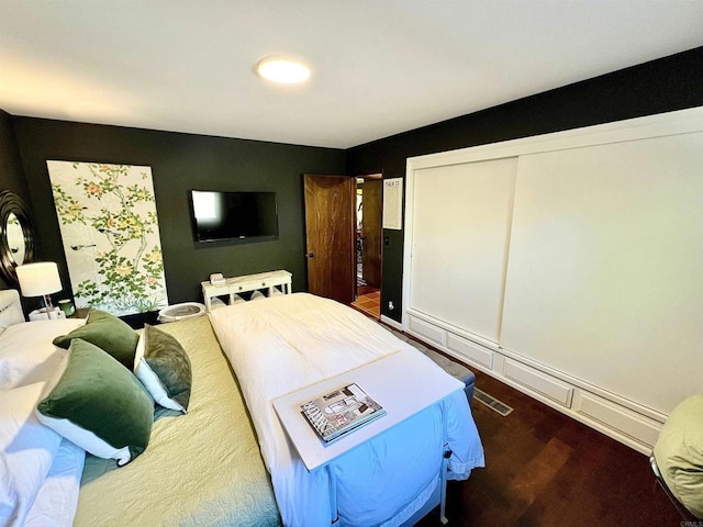 bedroom featuring dark wood finished floors and a closet