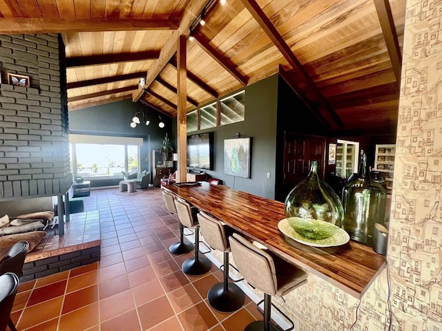 interior space with wood ceiling, tile patterned flooring, open floor plan, and vaulted ceiling with beams