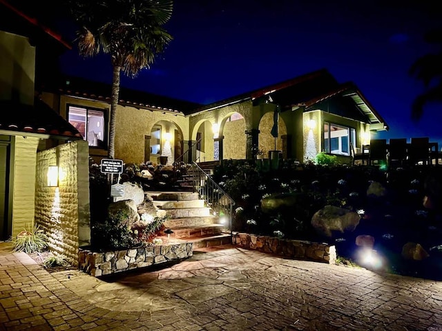 exterior space with stairway and stucco siding