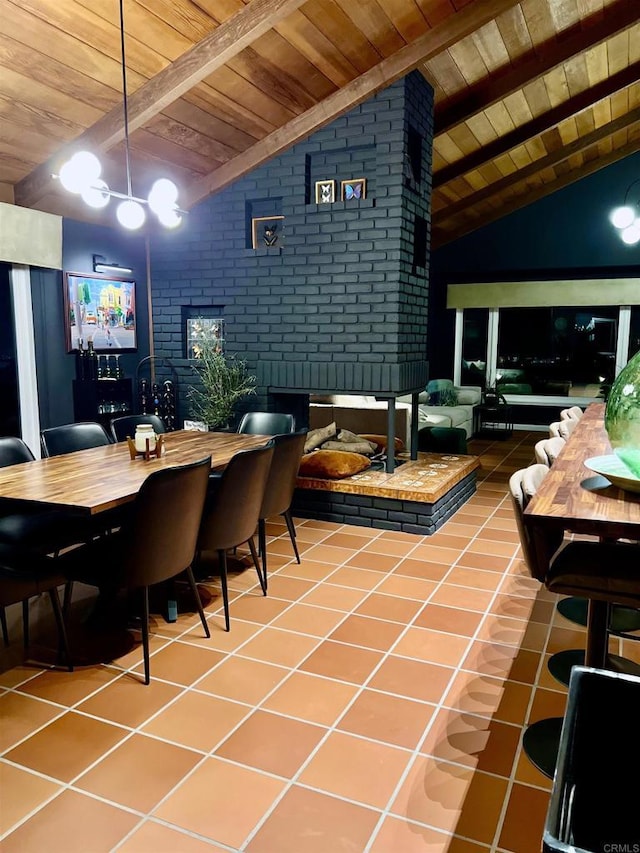 dining room with lofted ceiling with beams, tile patterned floors, and wooden ceiling