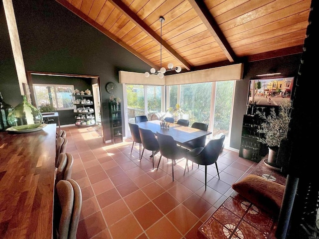 dining area featuring tile patterned floors, vaulted ceiling with beams, and wood ceiling