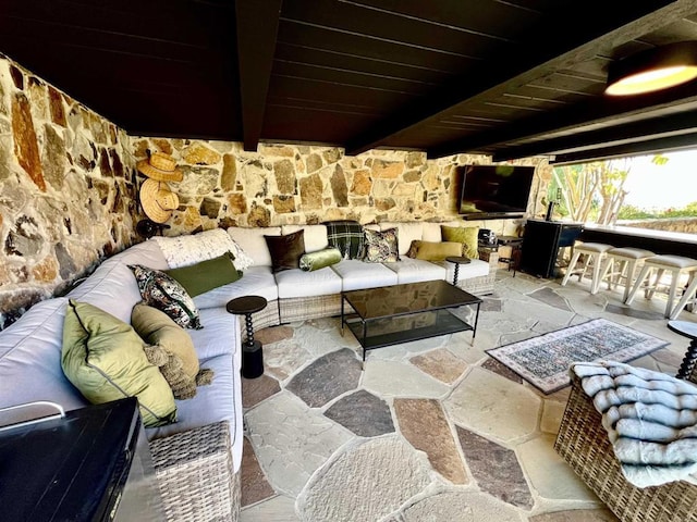 interior space featuring stone floors, beam ceiling, and wood ceiling