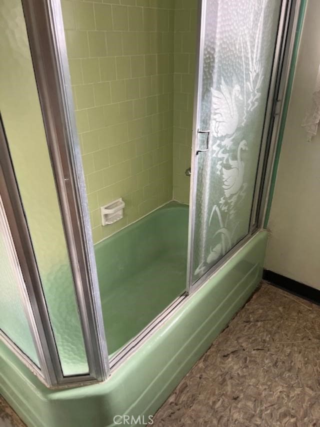 bathroom featuring bath / shower combo with glass door