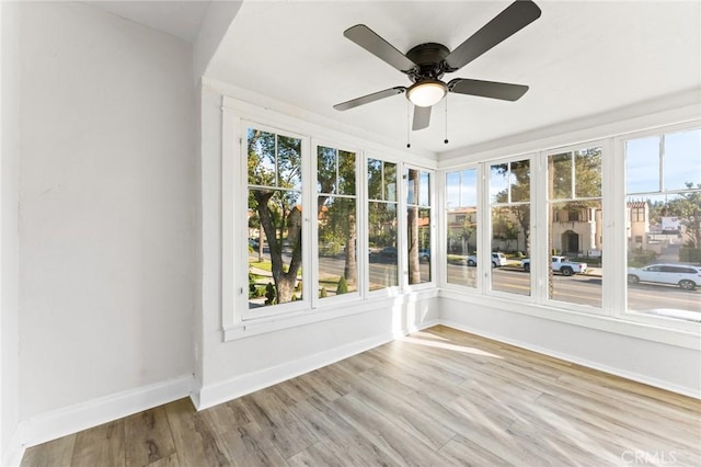 unfurnished sunroom with ceiling fan