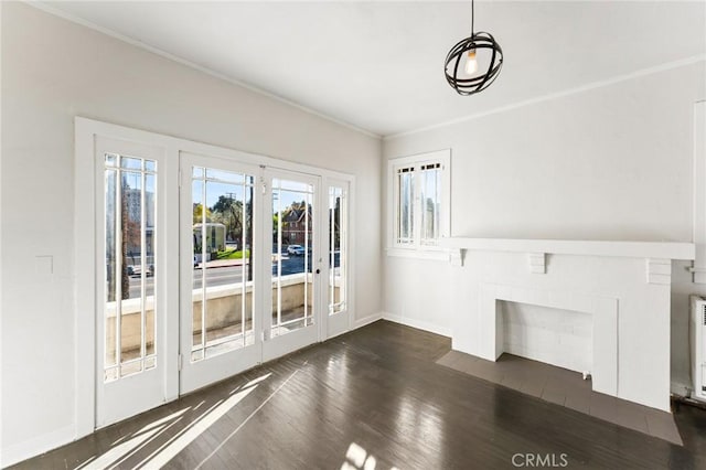 unfurnished living room featuring radiator, crown molding, french doors, and dark wood-type flooring