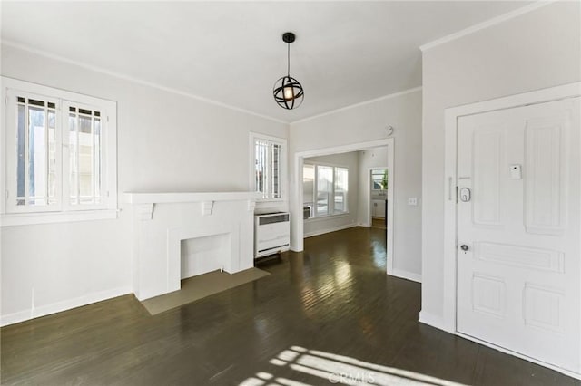 unfurnished living room with plenty of natural light, dark hardwood / wood-style floors, and crown molding