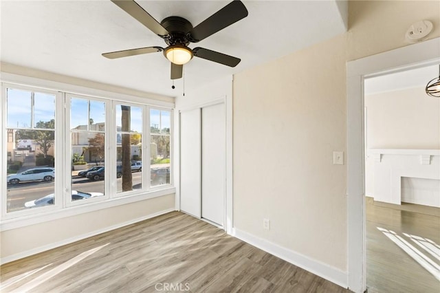 interior space with multiple windows, a closet, ceiling fan, and hardwood / wood-style flooring