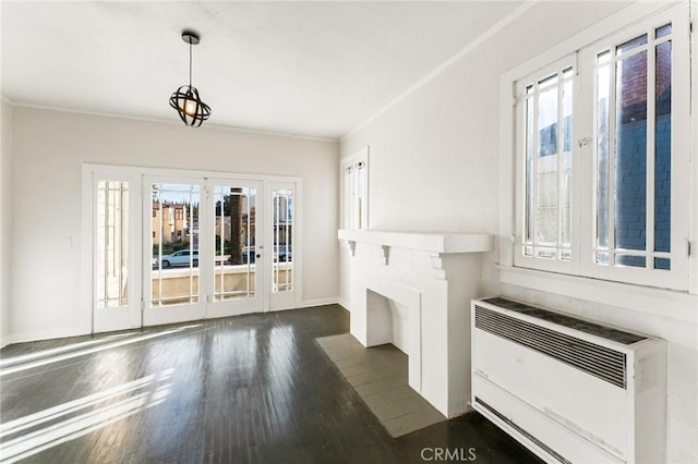 unfurnished living room featuring dark wood-type flooring and crown molding