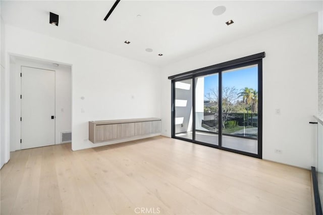 unfurnished room with light wood-style floors and visible vents