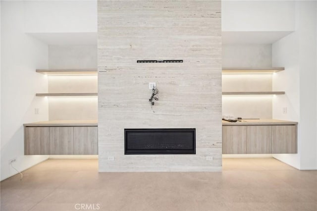 room details with a large fireplace and concrete flooring